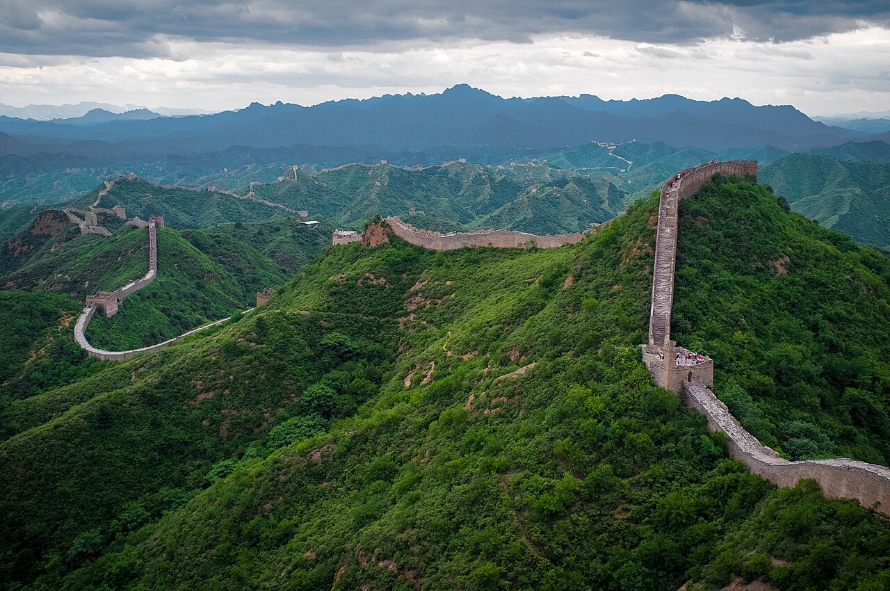 The Great Wall of China winding across green mountainous terrain at Jinshanling